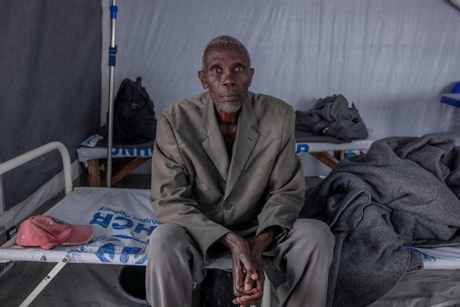 Shangoma Shabunyere, a 71-year-old man, sits on his sick bed undergoing treatment for cholera at the cholera treatment centre in the Rusayo camp for displaced people in the east of the Democratic Republic of Congo on 9 November 2023.

Following the outbreak of war in the east of the Democratic Republic of Congo, many people were forced to flee their homes to find refuge. More than 2.4 million people have been displaced in the east of the country and more than 34,000 cases of cholera have been recorded in North Kivu since January this year. The WHO and its partners are helping to improve sanitation and provide emergency health services to camp residents, but the needs in the region are enormous and further assistance is required.