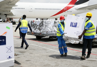 Workers offload boxes of AstraZeneca/Oxford vaccines as the country receives its first batch of coronavirus disease (COVID-19) vaccines under COVAX scheme, in Abidjan, Ivory Coast February 26, 2021. <br><br>504 thousand doses of the Astrazeneca / Oxford vaccine were received in Abidjan. Vaccination against COVID-19 begins March 1 in Côte d'Ivoire